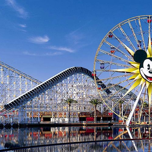 An amusement park scene with a large Ferris wheel featuring a Mickey Mouse face and a roller coaster named 